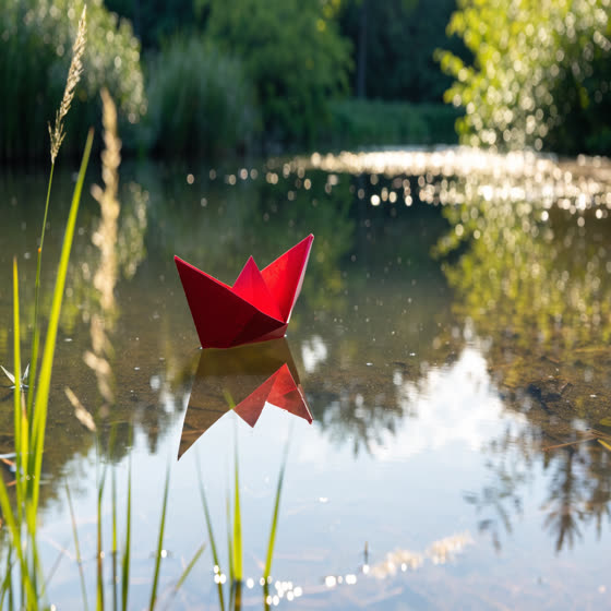 Recraft V4.1: Kata yang sama, mesin berbeda: “Perahu kertas merah mengapung di kolam tenang, cahaya pagi”. Pilih gaya yang Anda suka, lalu jadikan milik Anda.